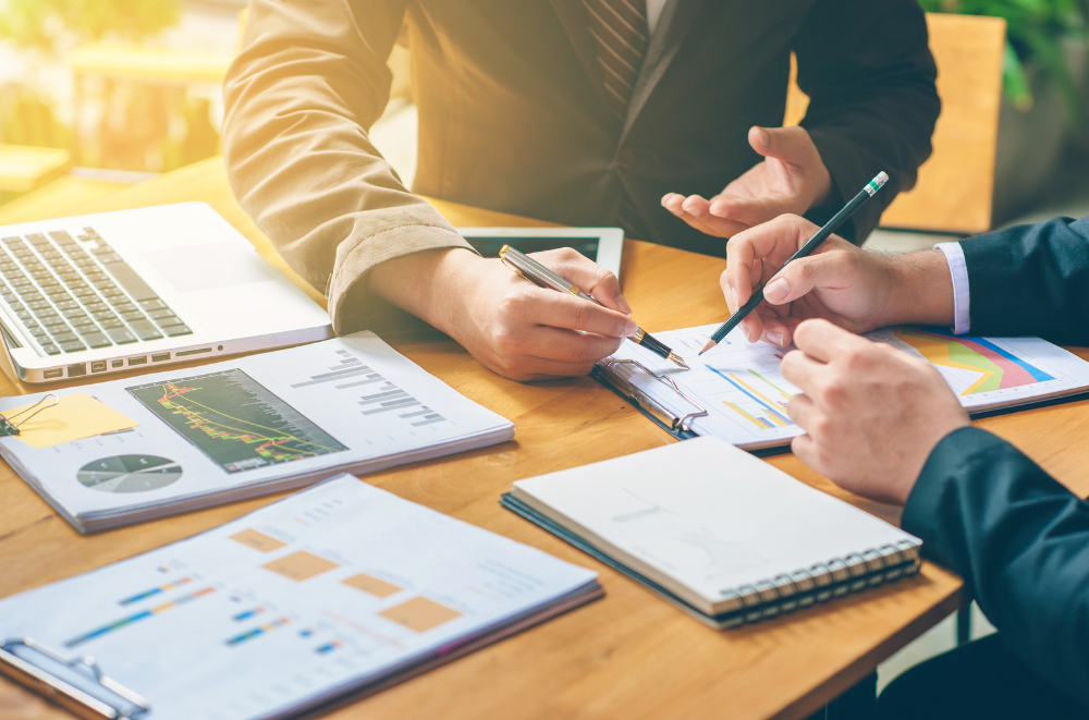 Two people reviewing financial documents and charts during a planning session